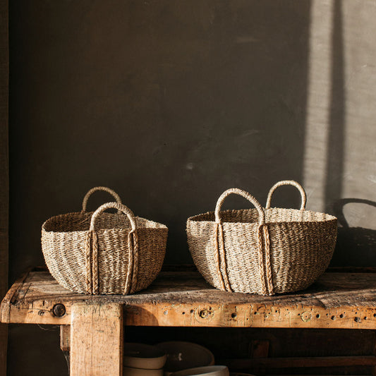 Deep oval handwoven seagrass basket with plaited handles, perfect for storing blankets, toys, or everyday essentials with rustic charm.