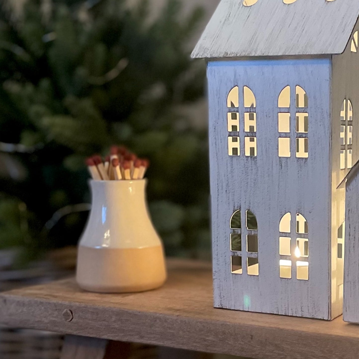 Handmade ceramic milk bottle match holder with long safety matches and hidden striker pad. Styled next to a candle house decoration.