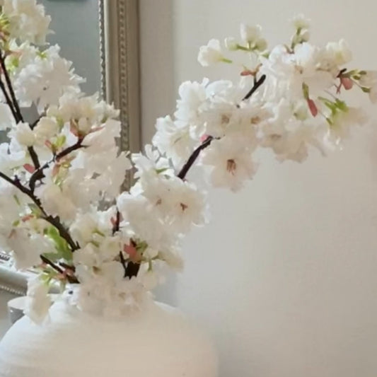 Faux Apple Blossom Stem with delicate white and pink blooms and green leaves, styled in a simple vase for elegant home decor.