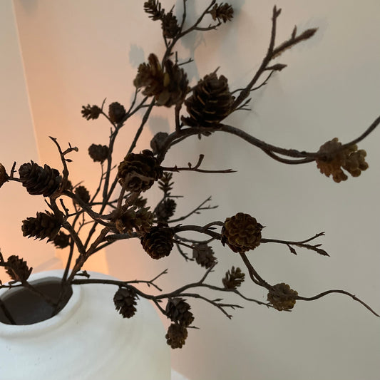 Faux pinecone spray with realistic mini pine cones. Styled in a white ceramic vase.