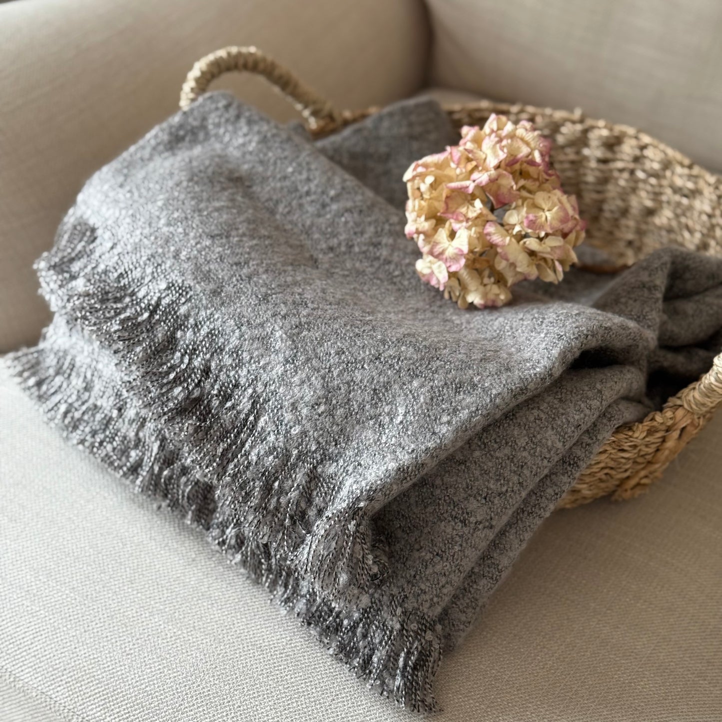 Soft, textural boucle throw styled on a sofa, perfect for creating a cosy, calm, and timeless atmosphere in your home.