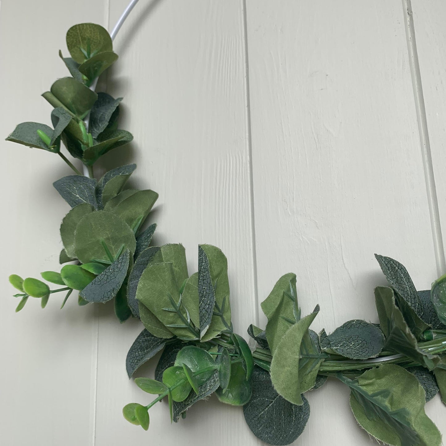 Decorative wreath with artificial greenery and jute hanger, perfect for neutral and rustic interiors.