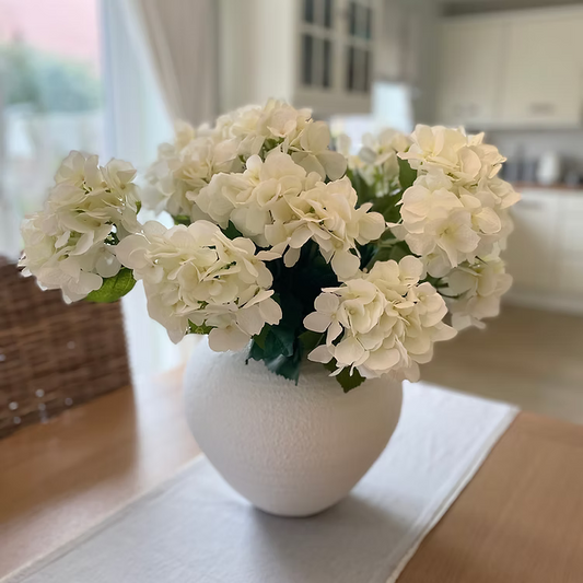 Lush white faux hydrangea bouquet, ideal for dining tables, windowsills, or coffee tables in neutral interiors.