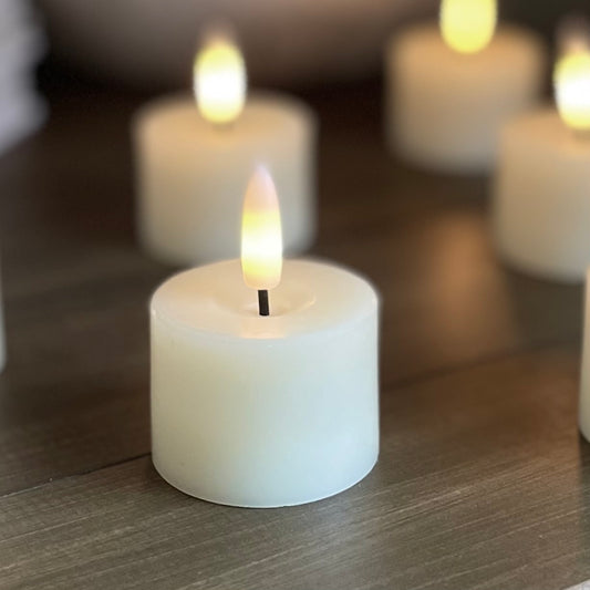 Set of realistic flameless tea lights creating a warm ambient glow.