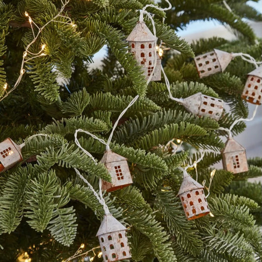 Rustic mini house LED lights used as festive decor. Styled on a christmas tree.