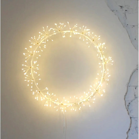 LED starburst wreath glowing with warm white lights on a rustic wall, creating a soft festive ambiance