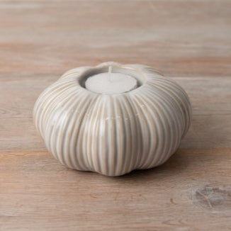 Two tone ceramic pumpkin tea light holder, styled on a wooden rustic table.