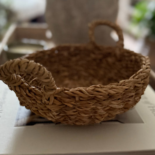 Natural woven basket used to store flannels, napkins, or styled with faux flowers, adding practical charm to a home.