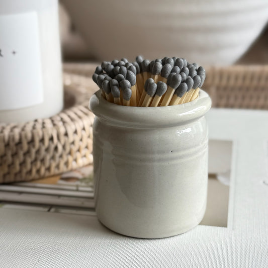 Handmade ceramic match striker crock pot with rustic glaze, styled beside a candle for a cosy, timeless look.