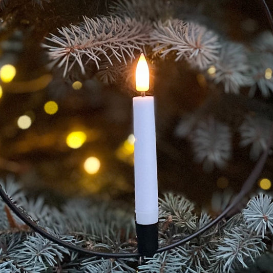 Black metal hanging ring with warm white LED candle and remote control, styled in a cosy interior setting.