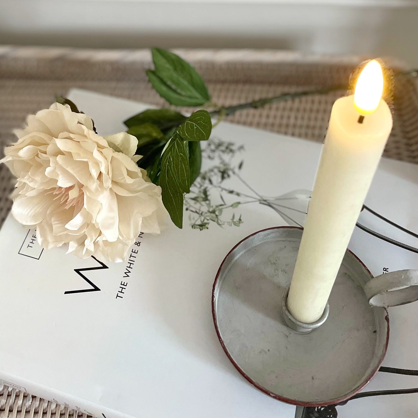 LED dinner candle with realistic flickering flame, 24 cm tall, styled on a dining table with a book.