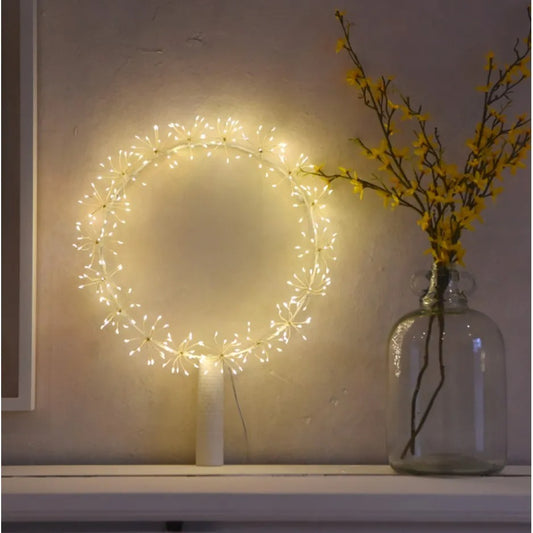 LED starburst wreath glowing with warm white lights on a rustic wall, creating a soft festive ambiance.