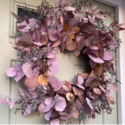 Amber Autumn wreath with russet faux foliage and berries on a grapevine base, styled on a rustic green wooden door.