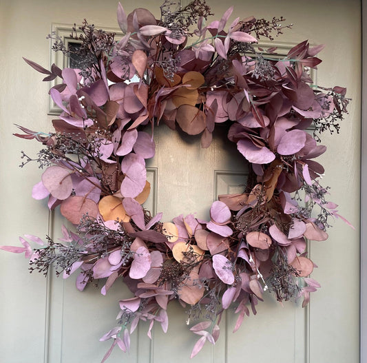 Amber Autumn wreath with russet faux foliage and berries on a grapevine base, styled on a rustic wooden door.