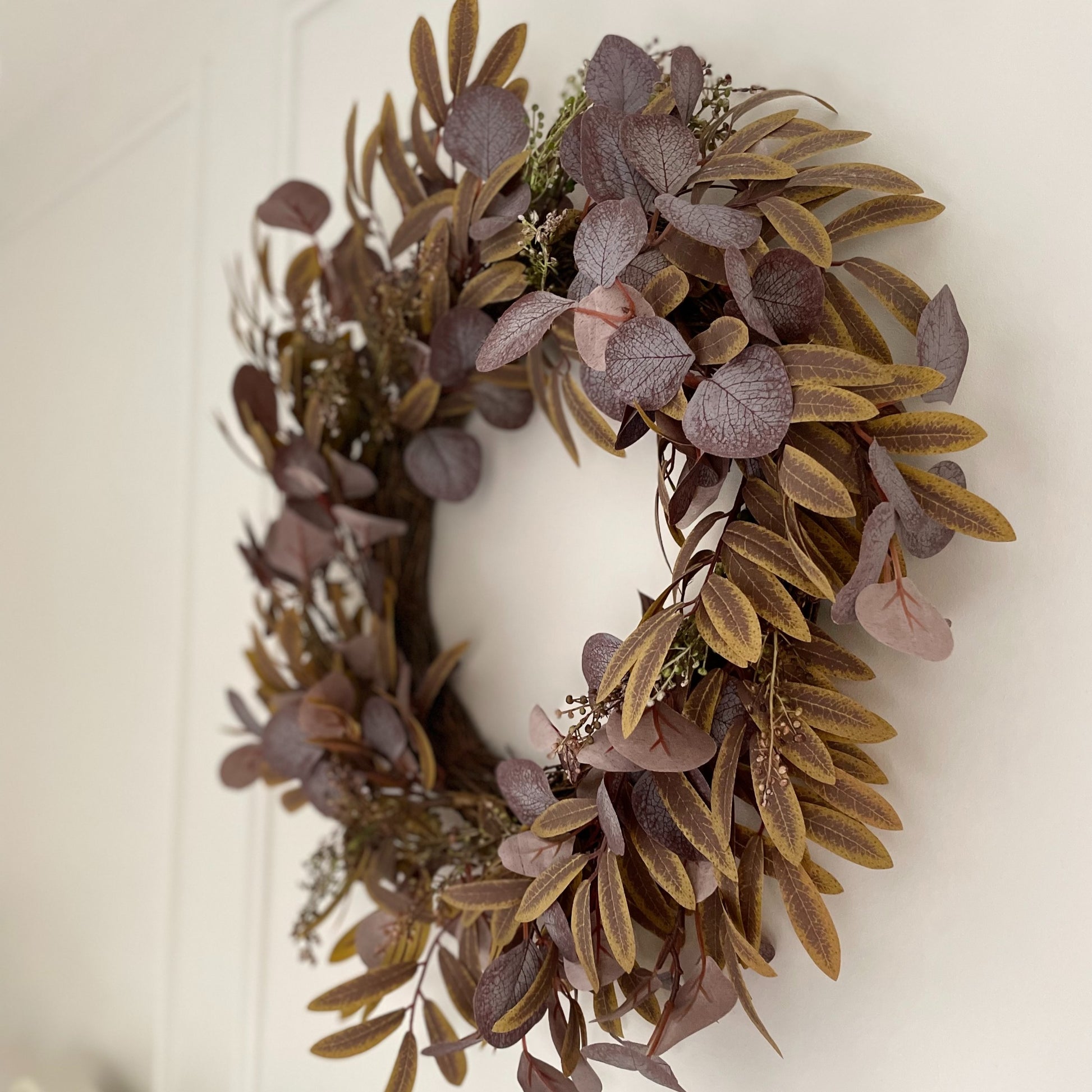 Full autumn foliage wreath with rich fall colours, styled as door or wall decor.