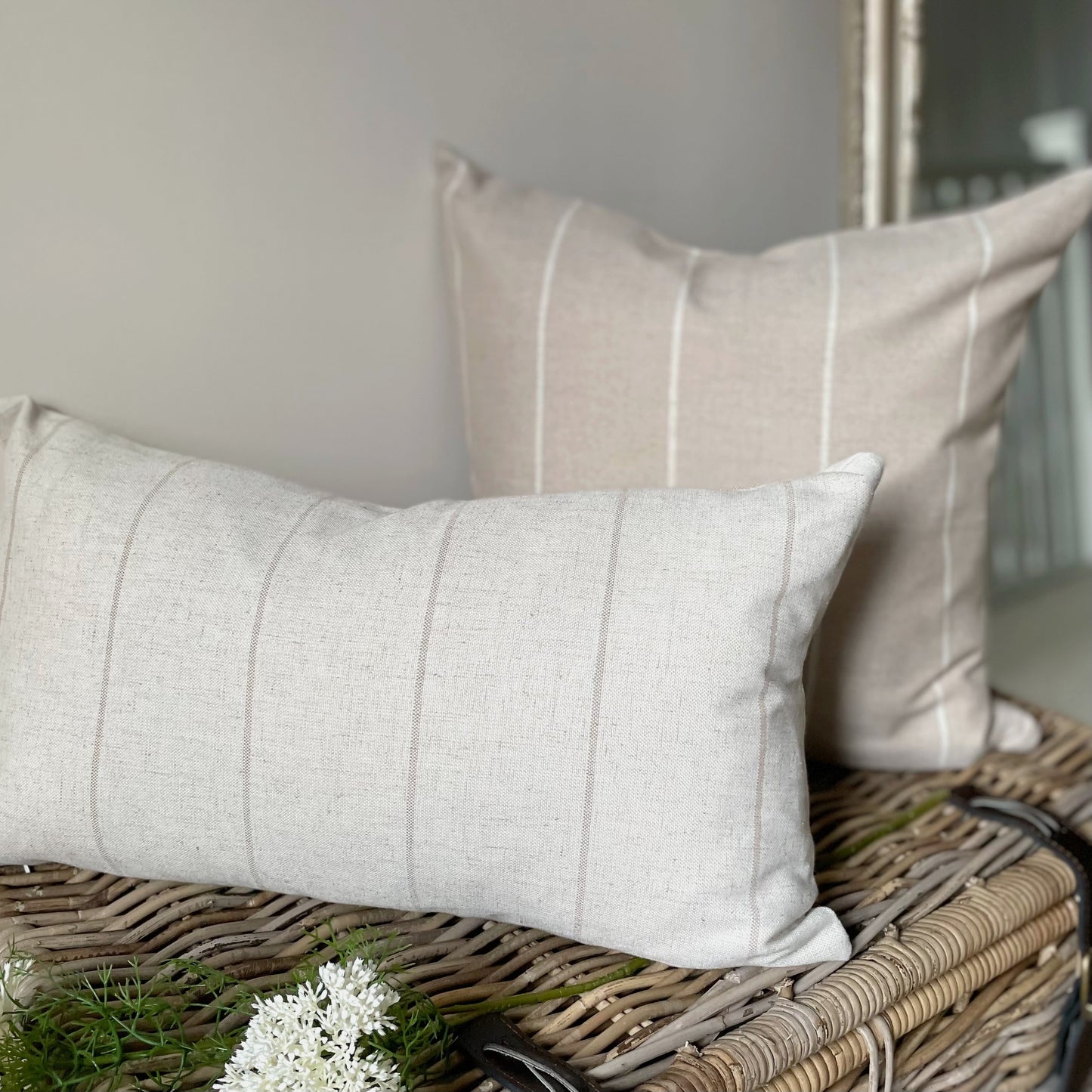 Natural linen blend cushion with thin beige stripes, styled on a neutral sofa for a relaxed country feel.