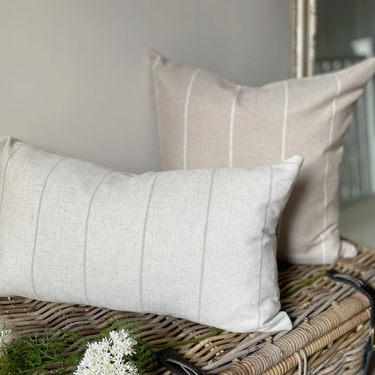 Natural linen blend cushion with thin beige stripes, styled on a neutral sofa for a relaxed country feel.