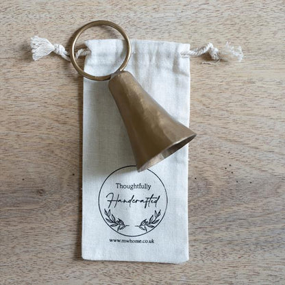 Candle snuffer on cotton presentation gift bag shown on a wooden table.