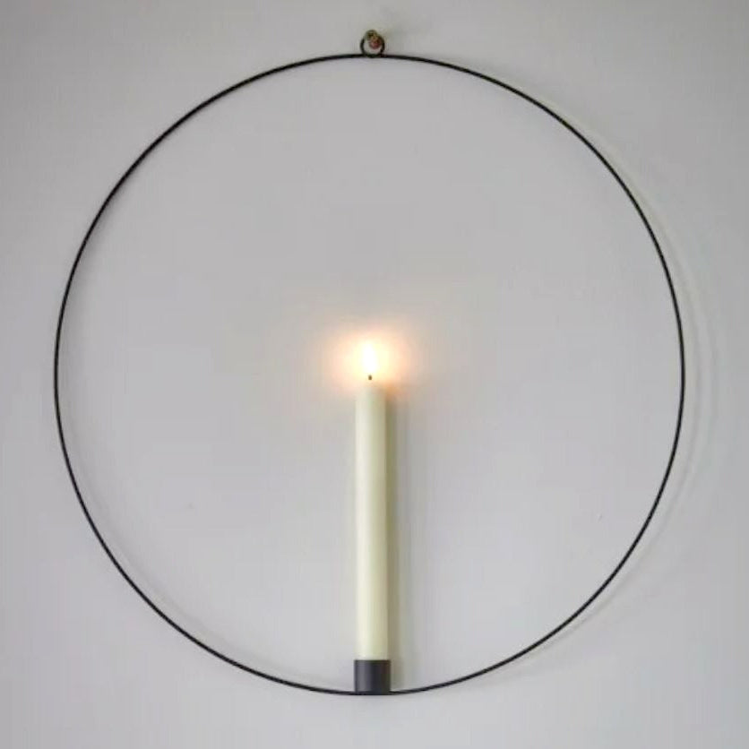 Warm white LED battery operated wax effect candle in a hanging black metal ring with remote control.