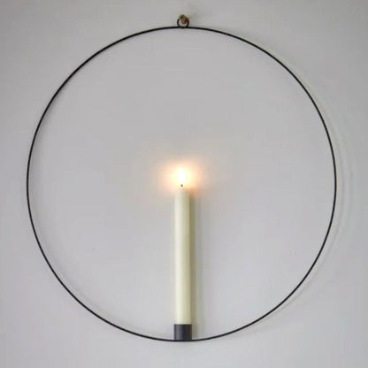 Warm white LED battery operated wax effect candle in a hanging black metal ring with remote control.