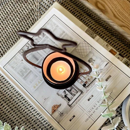Close up of black metal star tea light holder with glass candle votive.