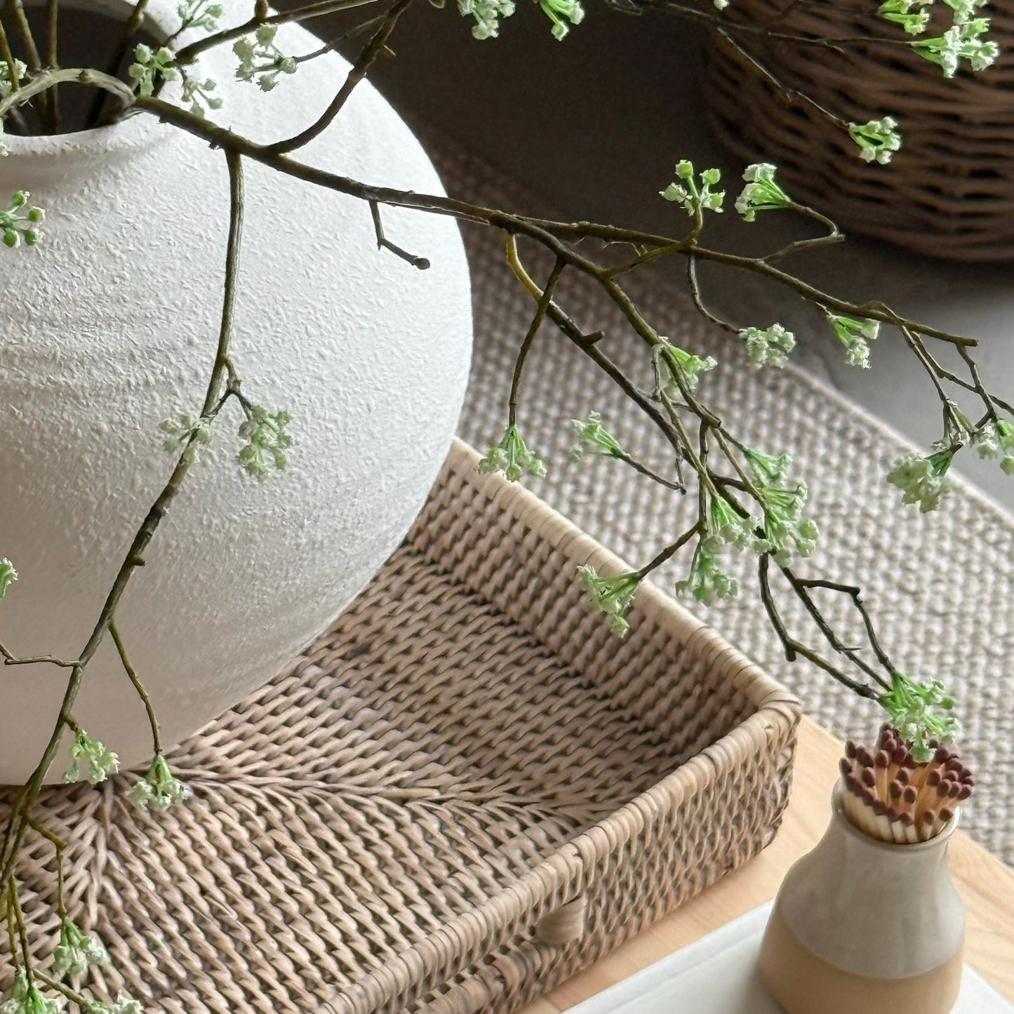 Woodland bloom faux branch arranged in a textured white ceramic vase with neutral home decor.