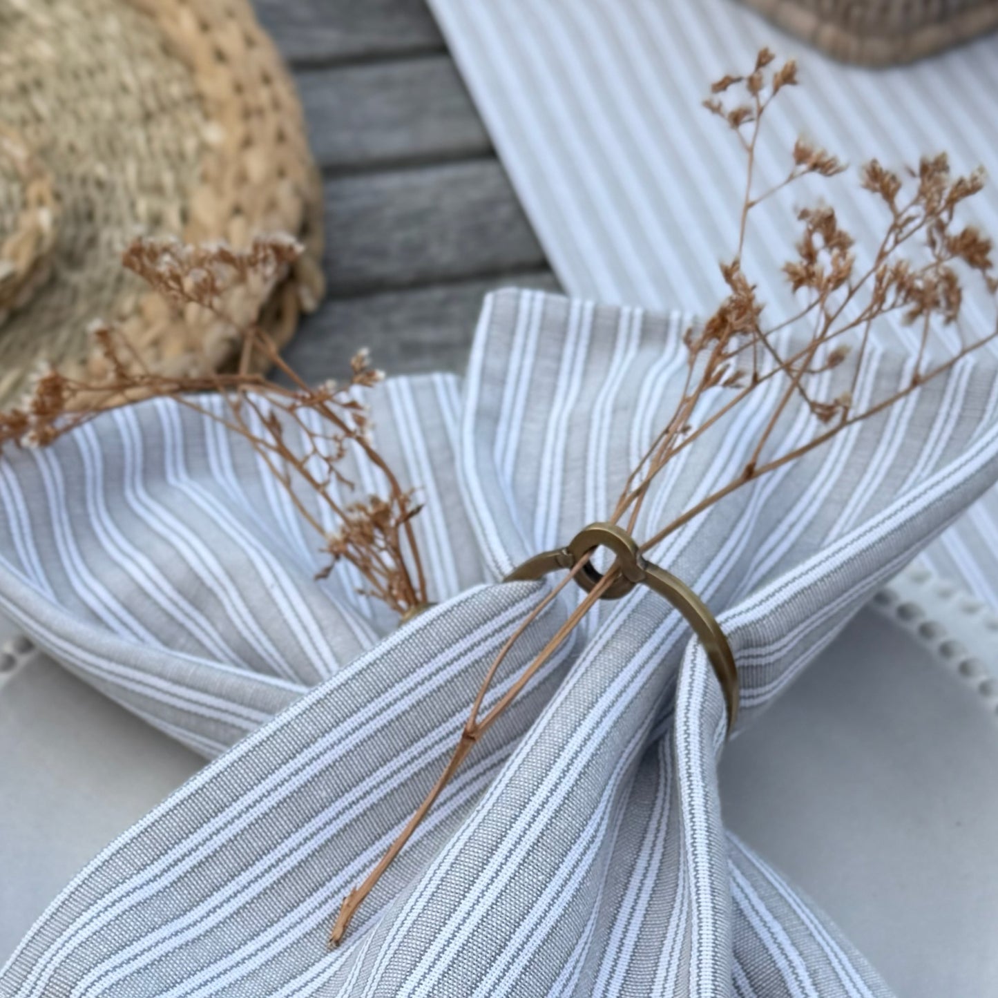 Elegant metal napkin rings styled on a table setting, perfect for adding timeless charm and seasonal touches like sprigs of rosemary or gypsophila.