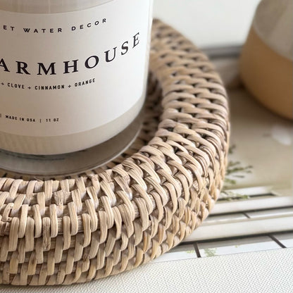 Woven rattan candle holder with a natural, textured design, holding a lit candle and adding warm, rustic charm.