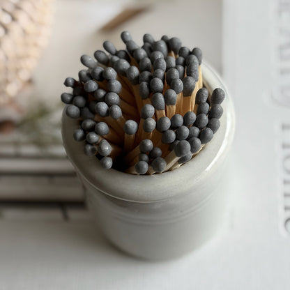 Small glazed crock pot match striker with bundle of long matches, showcasing artisan craftsmanship and rustic charm.
