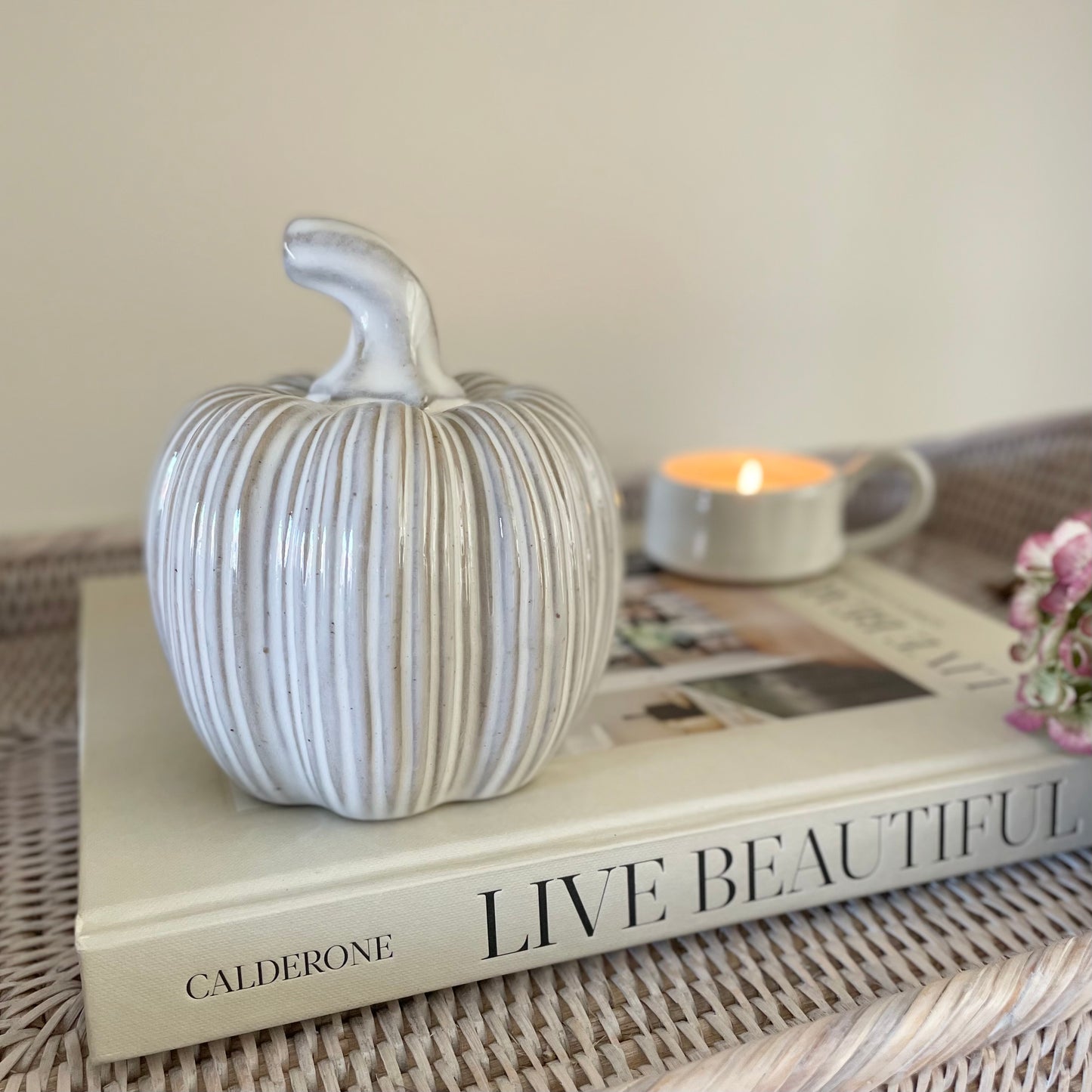 Two tone ceramic pumpkin adding rustic seasonal charm to a neutral living room interior.