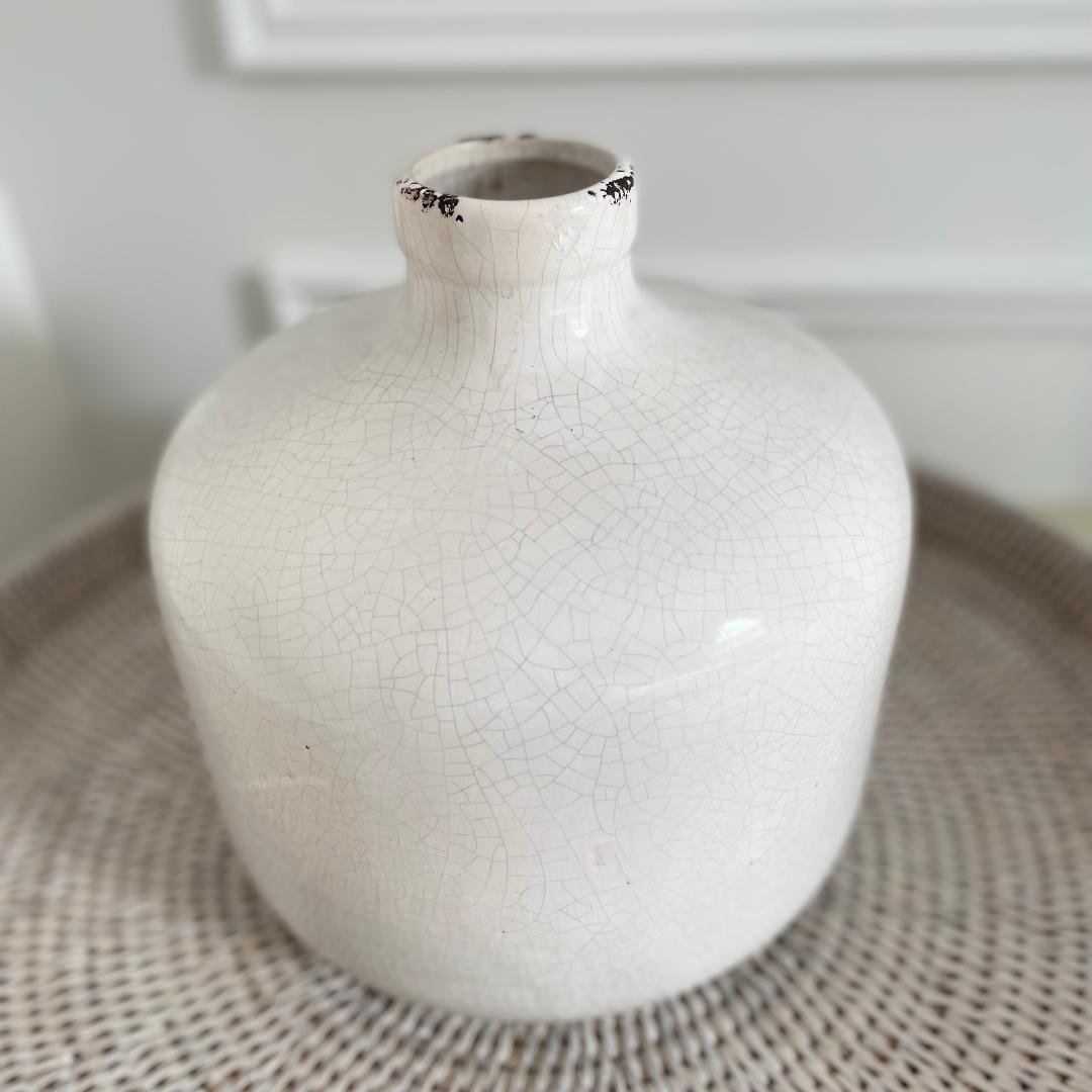 Neutral crackled ceramic Garda Vase with distressed finish, styled on a rattan tray.