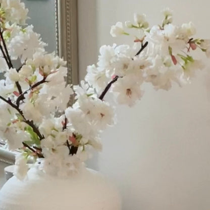 Faux Apple Blossom Stem with delicate white and pink blooms and green leaves, styled in a simple vase for elegant home decor.