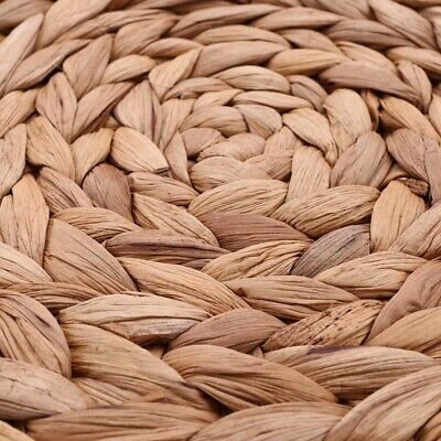 Close up of round woven water hyacinth placemat showing its tight, natural weave and rustic organic texture.