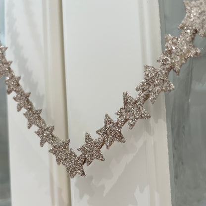 Heart shaped gold glitter star wreath hanging from natural jute string.