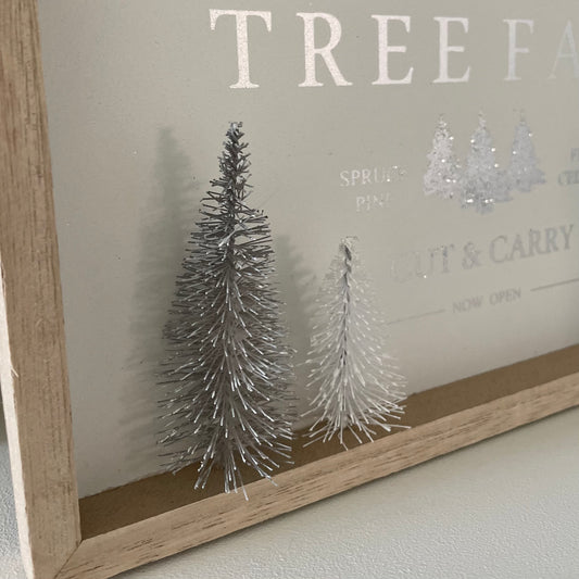 Wooden Christmas plaque with “Christmas Tree Farm” text, snowy bristle trees, and jute hanger in neutral tones.