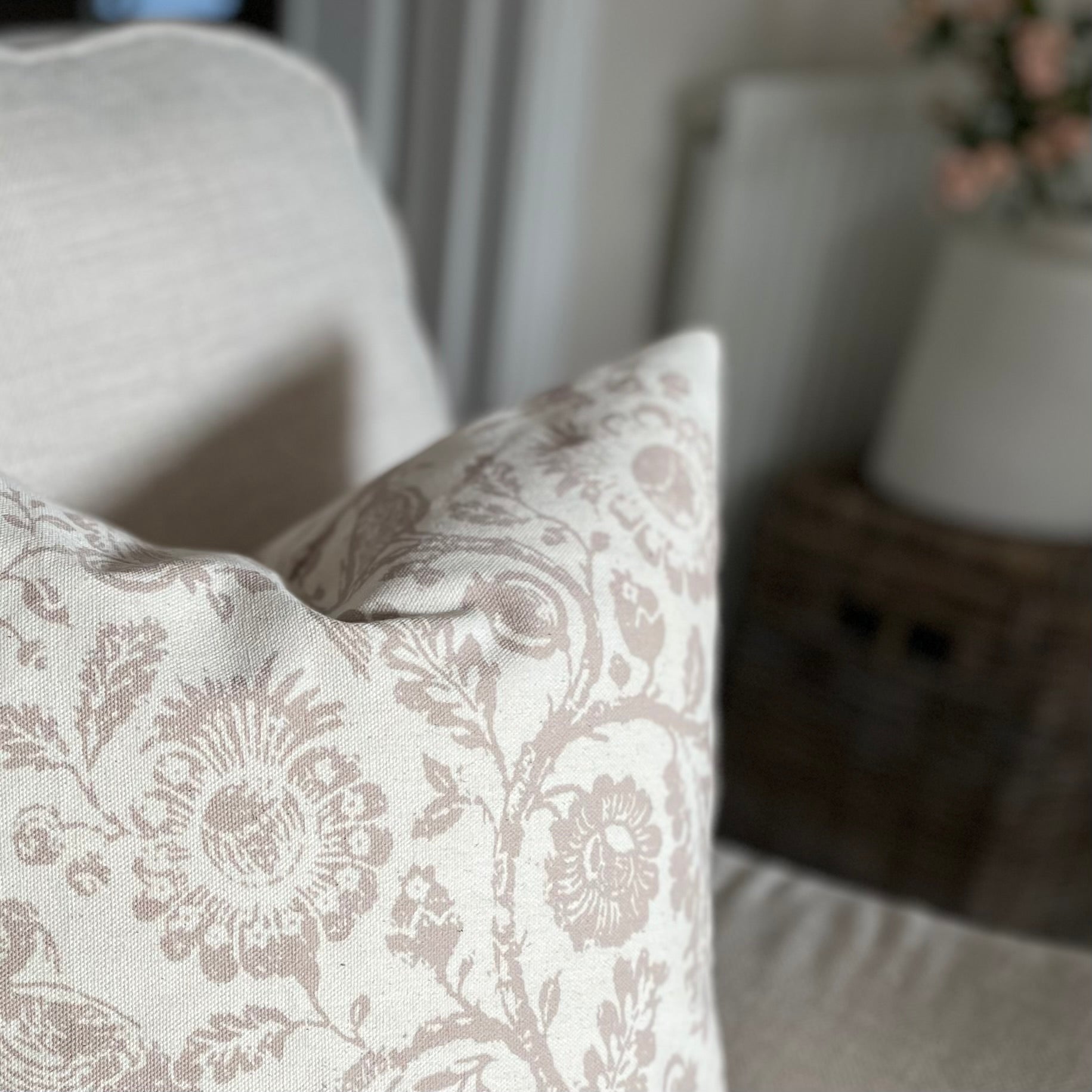 Taupe patterned cushion with a subtle country inspired print, styled on a neutral sofa.
