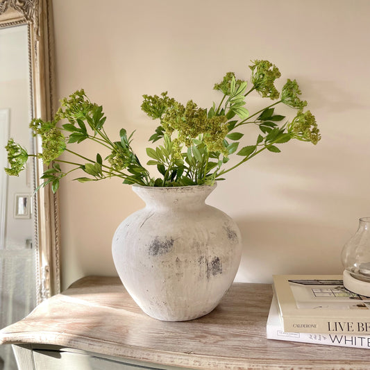 Faux Cow Parsley stem styled in a stone vase on a rustic console table, white books and a lantern.