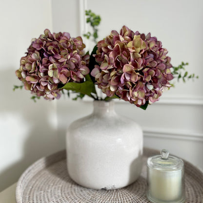 Neutral crackled ceramic Garda Vase with distressed finish, styled with soft greenery on a rustic wooden console table.