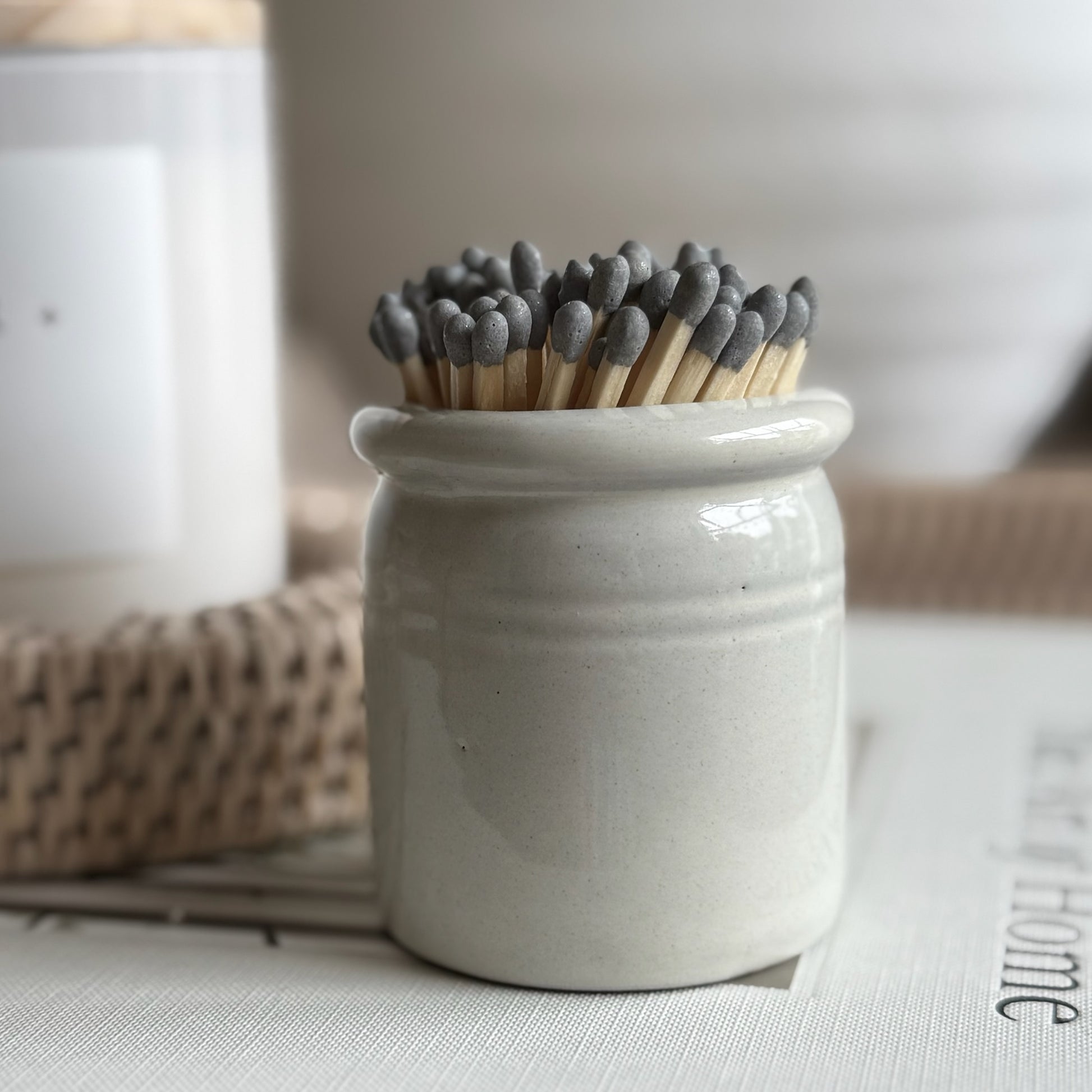 Ceramic match striker pot with hand-painted glaze and matches, perfect for styling on a mantel or gifting to a home lover.