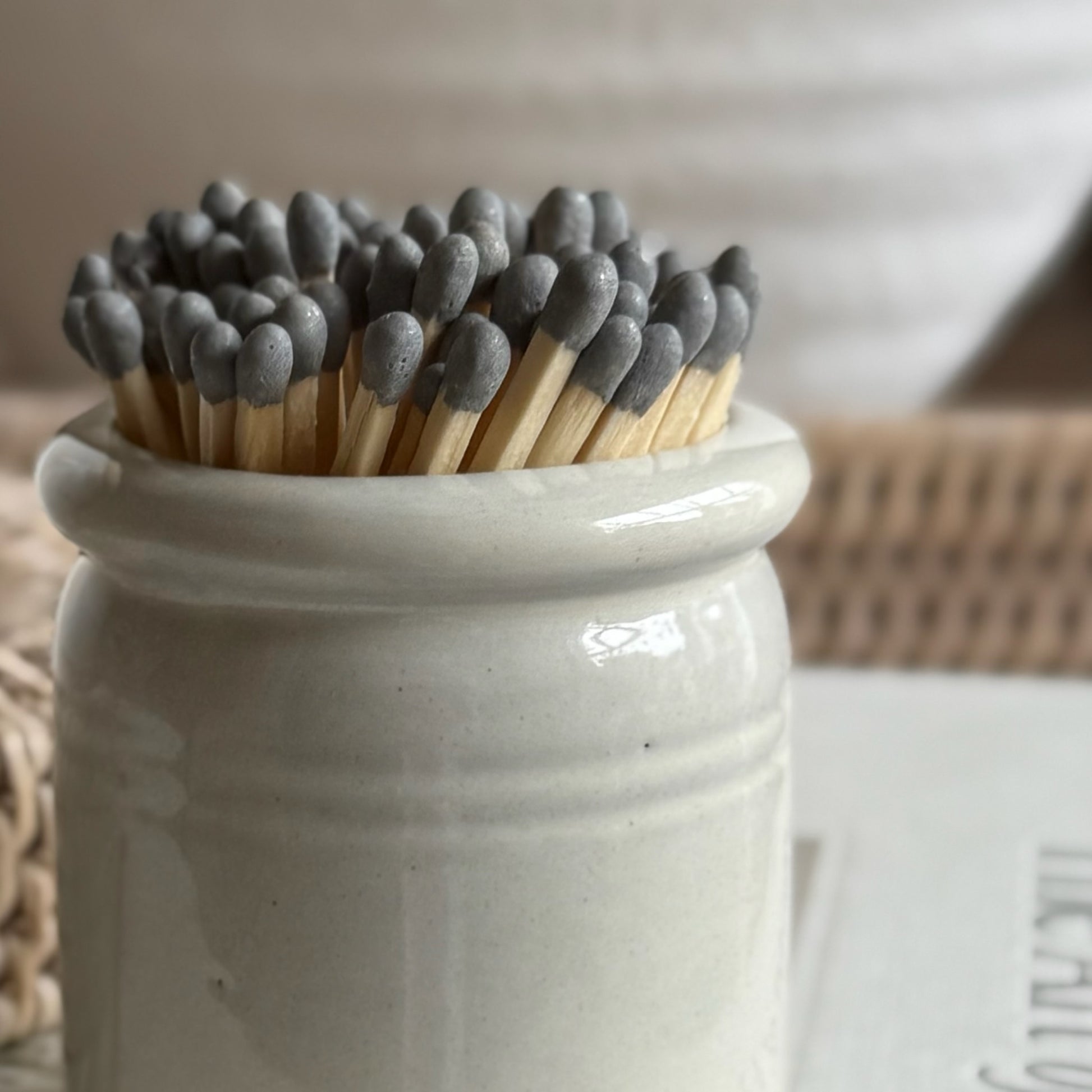 Handmade ceramic match striker crock pot with rustic glaze, styled beside a candle for a cosy, timeless look.