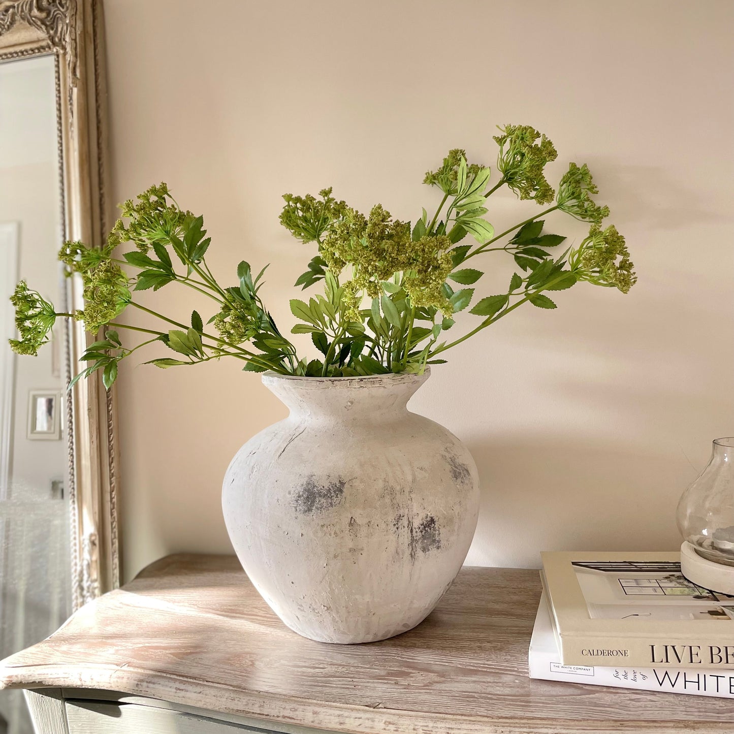 Darcy stone textured vase in white and grey tones styled with faux flowers on a wooden console table.