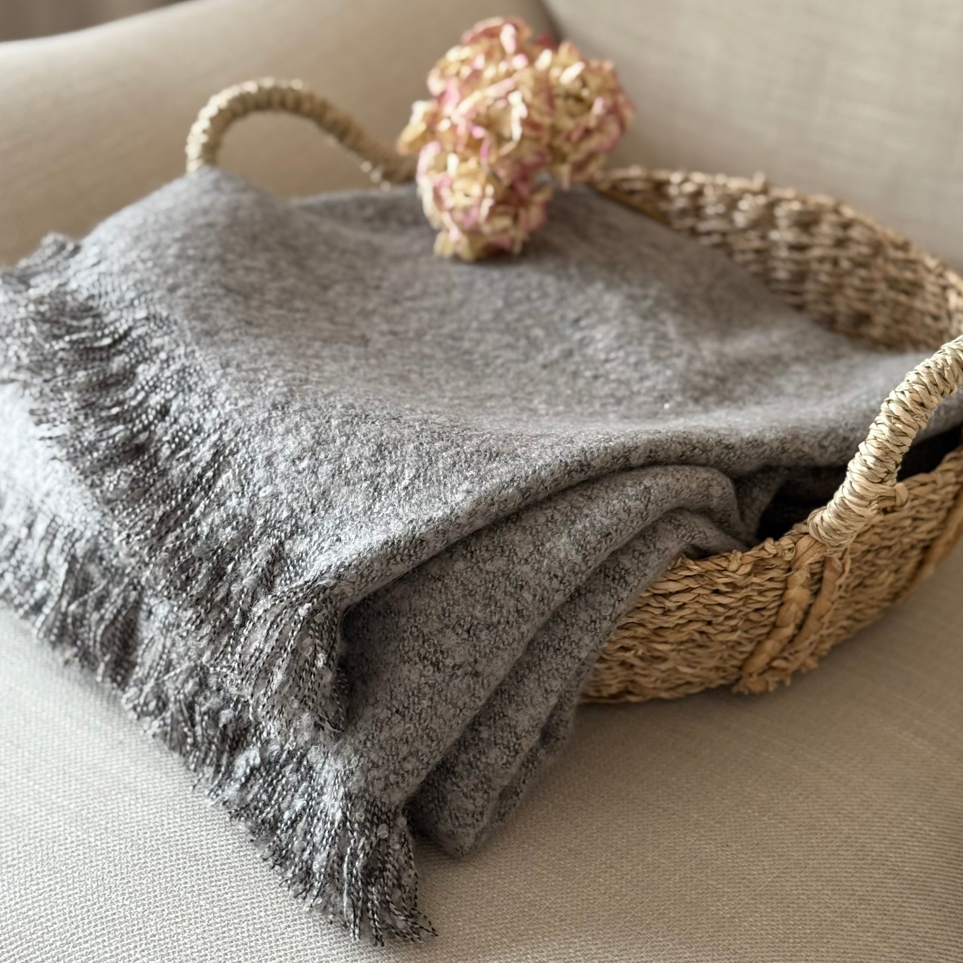 Soft, textural boucle throw styled on a sofa, perfect for creating a cosy, calm, and timeless atmosphere in your home.