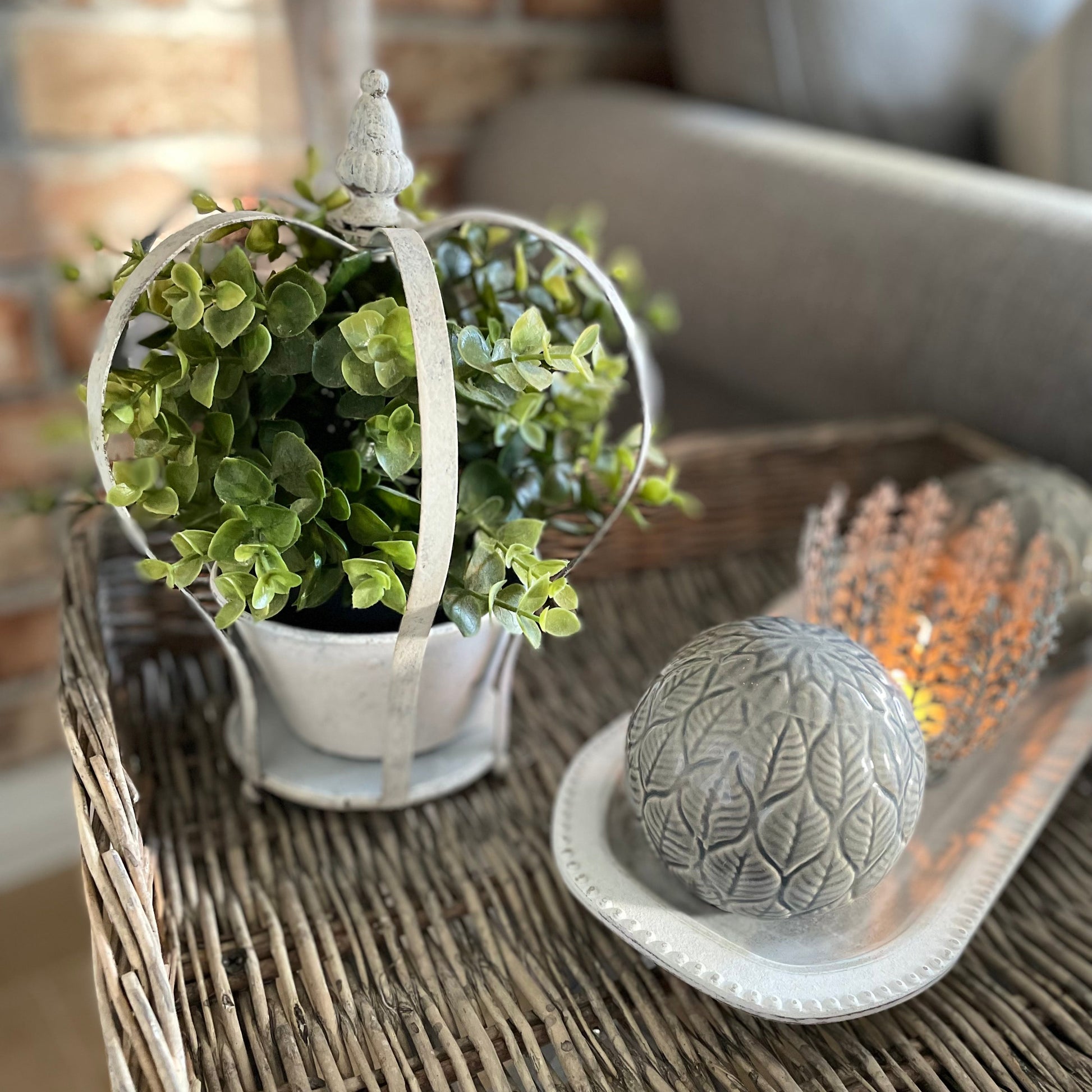 Decorative candle holder shaped like a crown with a lit candle on a wicker tray.