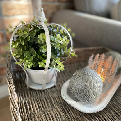 Decorative candle holder shaped like a crown with a lit candle on a wicker tray.