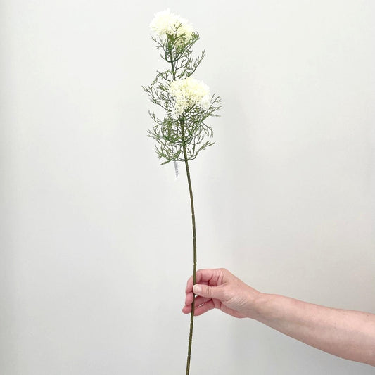 Faux elderflower spray with two clusters of white buds held on a white background.