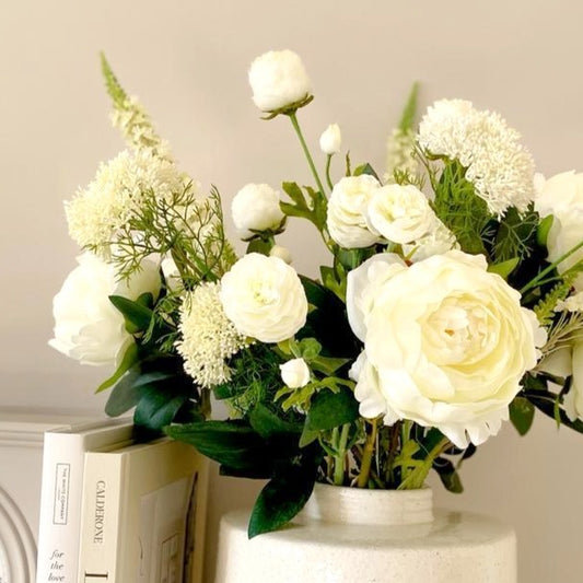 Faux elderflower spray with two clusters of white buds styled in a flower arrangement and vase.