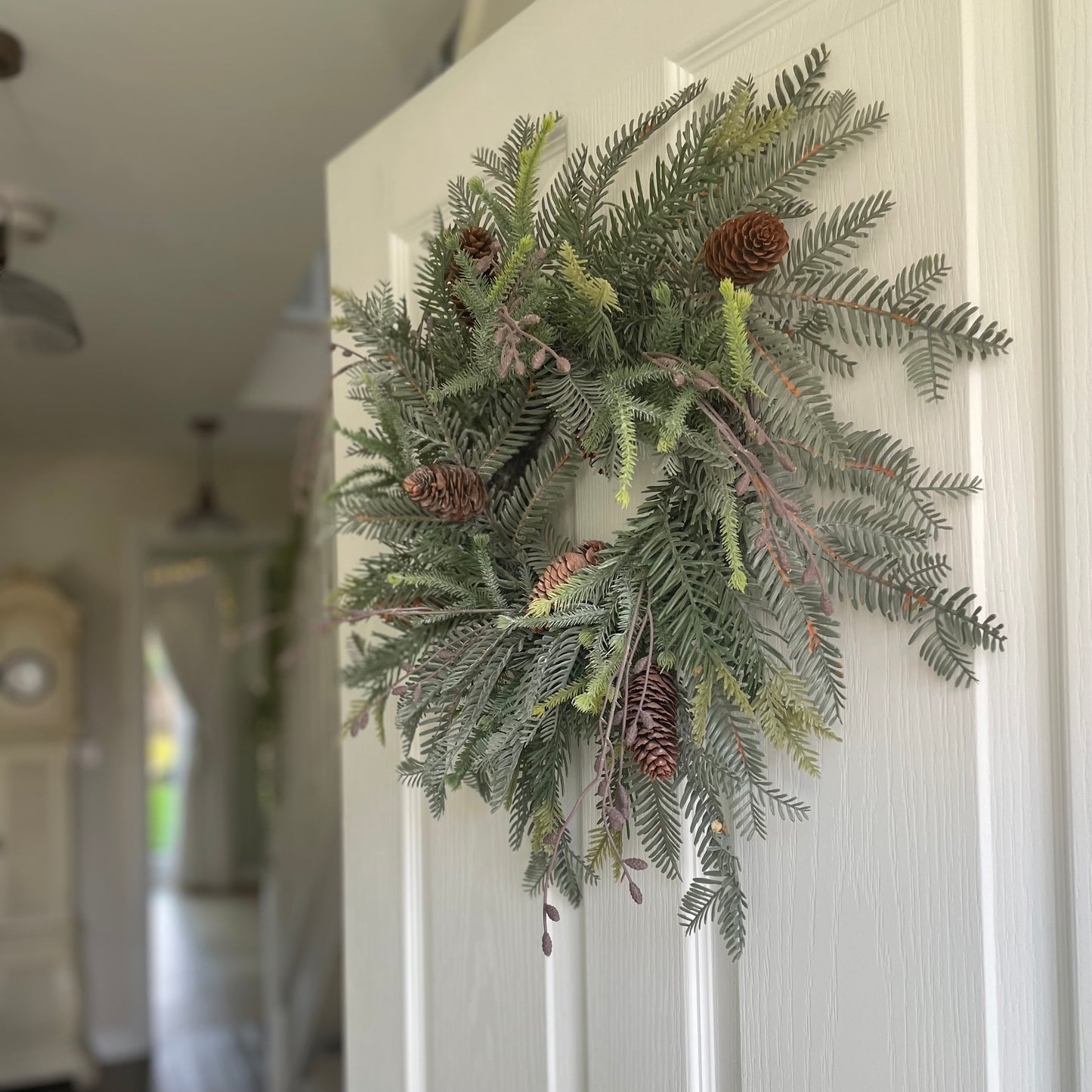 Faux woodland wreath styled on front door for festive decor. 