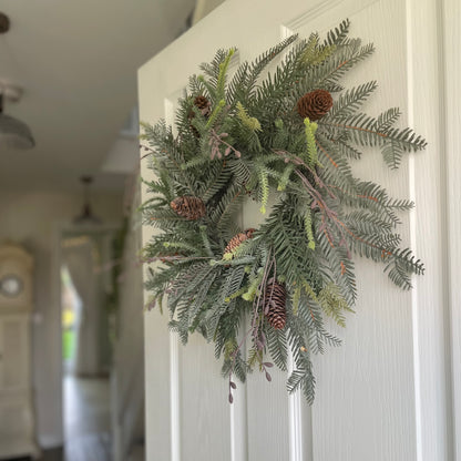 Faux woodland wreath styled on front door for festive decor. 
