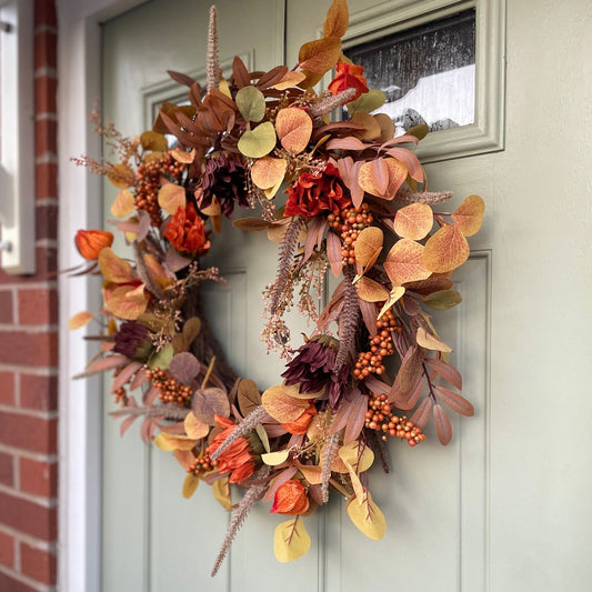 Sacha Autumn Wreath with russet faux foliage, berry sprigs and autumn flowers on a large grapevine base, styled on a front door.