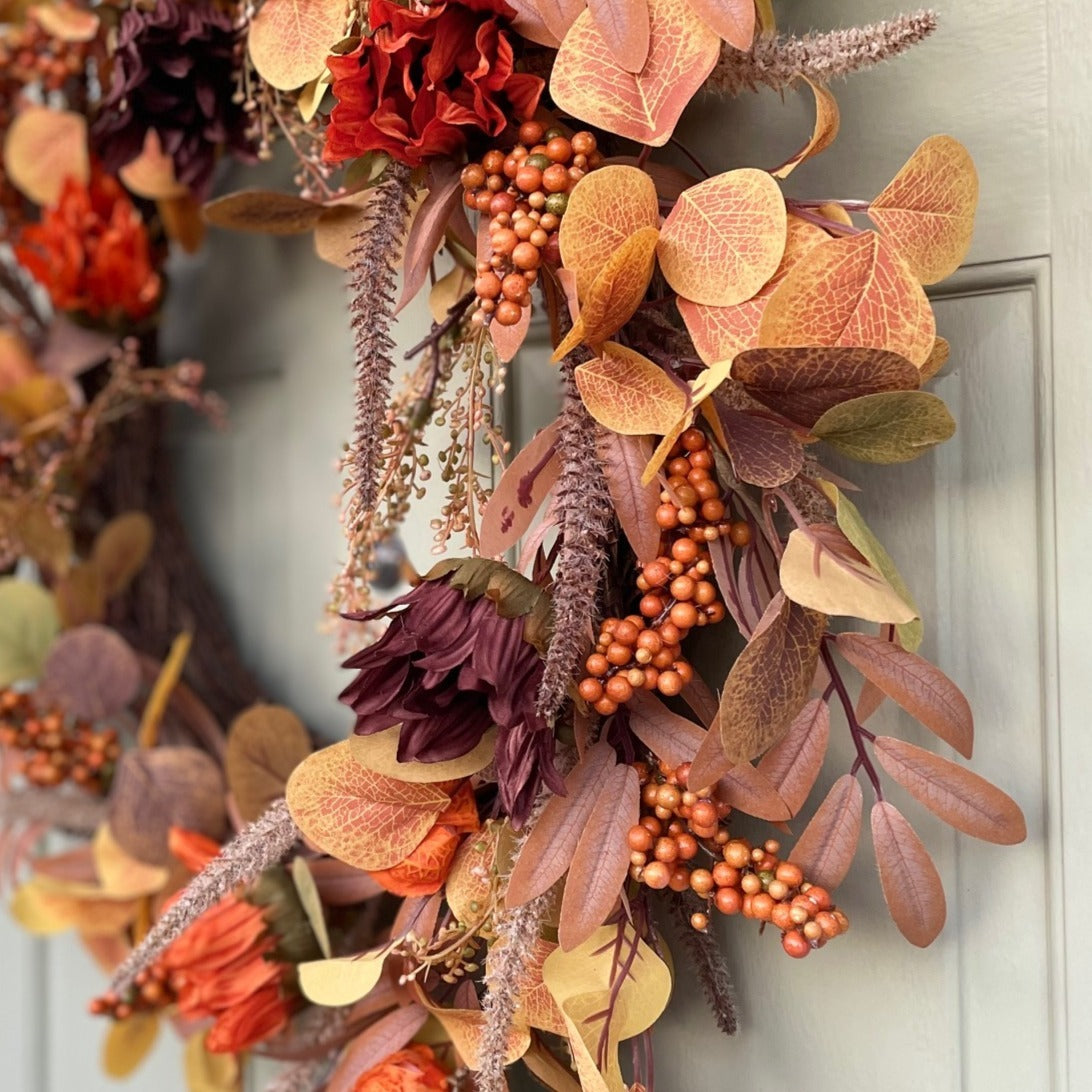 Sacha Autumn Wreath with russet faux foliage, berry sprigs and autumn flowers on a large grapevine base, styled on a front door.